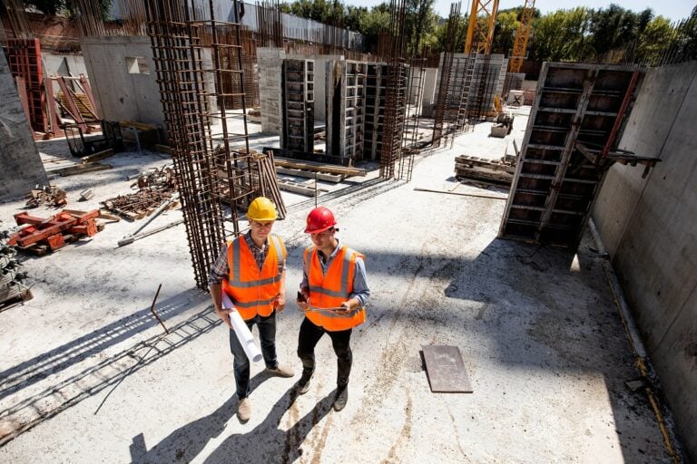 Civil engineer and architect dressed in high vis orange vest on site