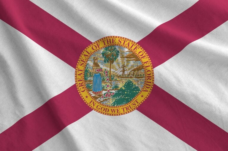 Florida us state flag depicted on folded wavy fabric of old cloth